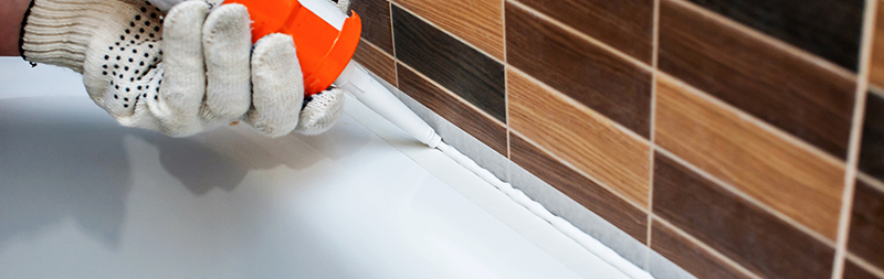 Nanášení silikonu v koupelně